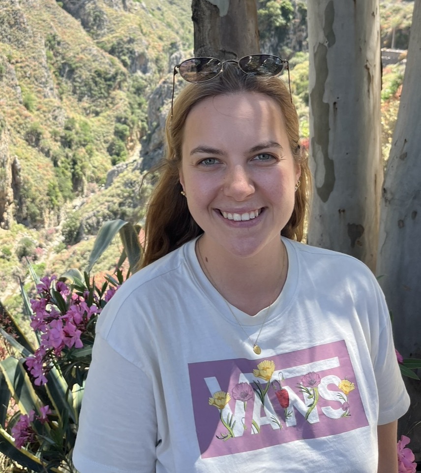 Profilbild von Isabella. Im Hintergrund Blumen und Bäume.